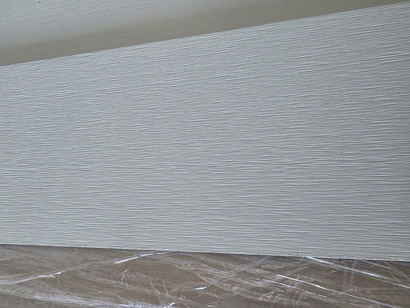 Närbild av vit fibercementpanel med trästruktur – RAL 9010